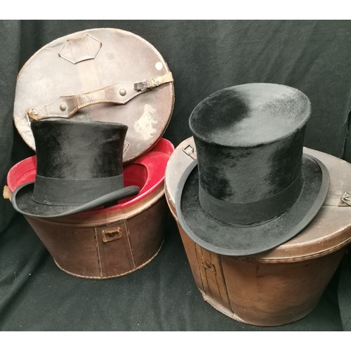109 - 2 Victorian leather hat boxes t/w 2 silk top hats, one Christies and the other UCL, in good conditio... 