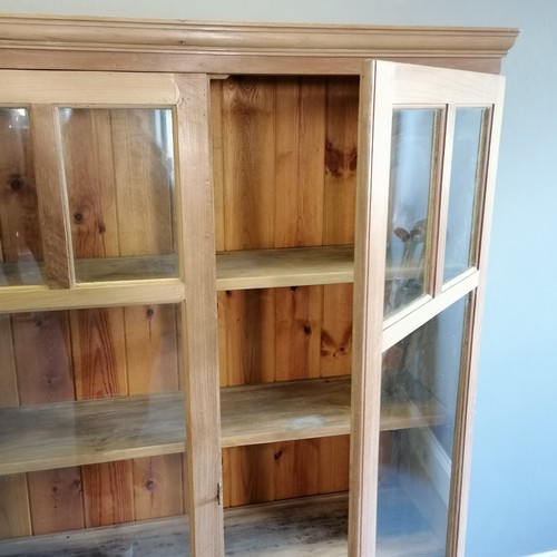 183 - Antique stripped pine double glazed door cabinet, with open shelf to base, 105 cm wide, 31 cm deep, ... 