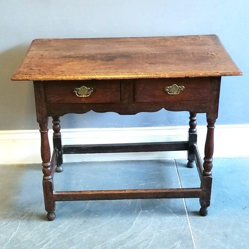 198 - Antique oak 2 drawer side table, with brass drop handles, turned column supports, marks to the top b... 