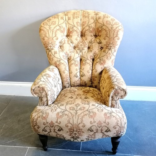 201 - Victorian style button back armchair upholstered in a floral tapestry beige coloured material, in go... 