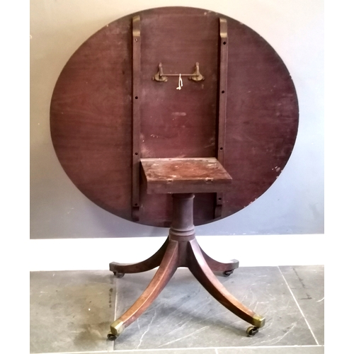 219 - Antique mahogany Oval tilt top table, turned column on splayed legs terminating brass castors, 122 c... 