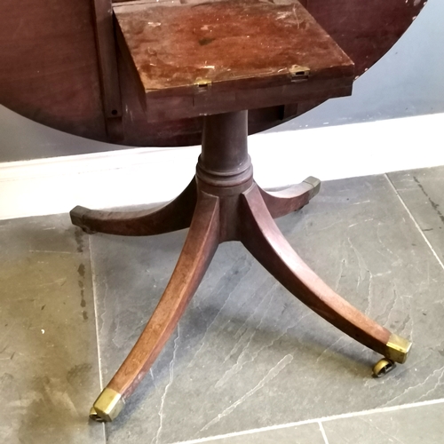 219 - Antique mahogany Oval tilt top table, turned column on splayed legs terminating brass castors, 122 c... 