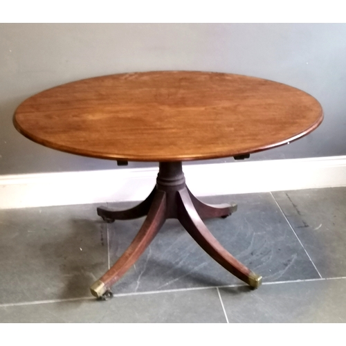 219 - Antique mahogany Oval tilt top table, turned column on splayed legs terminating brass castors, 122 c... 