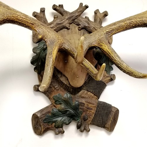 228 - Set of mounted 12 point antlers on a Black forest carved and painted shield 75cm wide x 100cm high