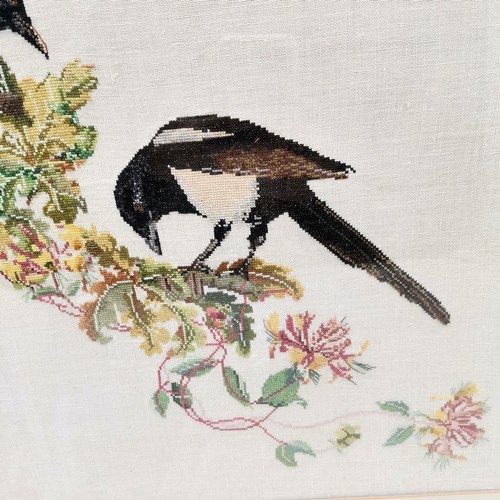 231 - Framed needlework picture of a pair of Magpie's 77 cm wide, 64 high, to include frame.