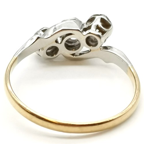 323 - 18ct gold & platinum 3 stone diamond crossover ring - size P½ & 2.7g total weight. Has wear to setti... 