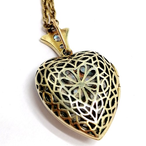 464 - Unmarked heart shaped locket pendant set with opalescent stones on a 9ct marked gold 50cm chain - to... 