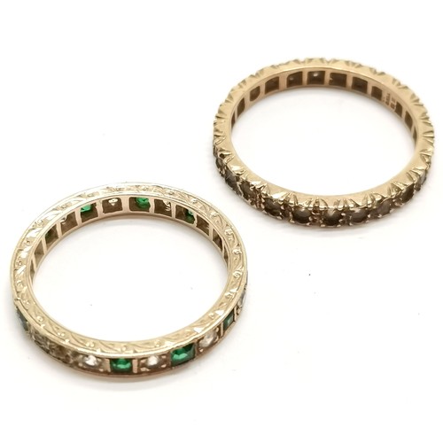 566 - 2 x gold stone set eternity rings (1 unmarked) - size P & T and total weight (2) 5g ~ the green ston... 