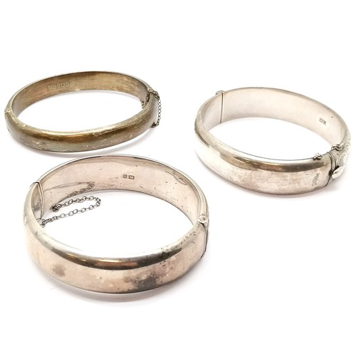 593 - 3 x silver hallmarked bangles - all with engraved detail ~ 64g ~ slight dents to 1 bangle