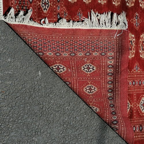 92 - Large Pakistani Bokhara late 20th century carpet in red. Measures 302 x 225cm. In good used conditio... 