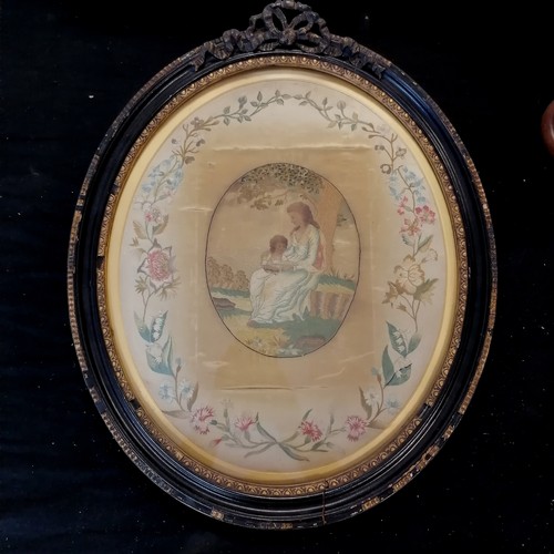 93 - Antique oval framed needlework picture of mother and child with a border of flowers frame size 50cm ... 