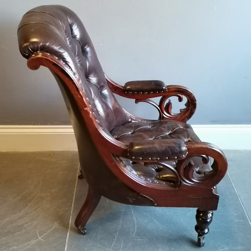 199 - Antique mahogany framed leather upholstered button back library chair, with scroll arms in good cond... 