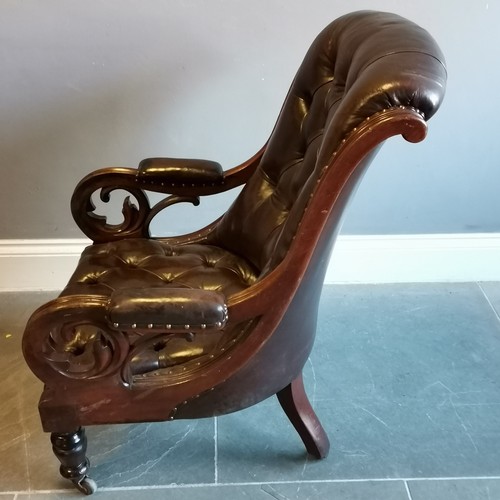 199 - Antique mahogany framed leather upholstered button back library chair, with scroll arms in good cond... 