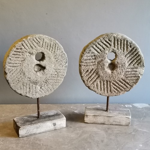 212 - Matched pair of sandstone mill stones mounted on a iron rod and driftwood bases, 32 cm wide, 11 cm d... 