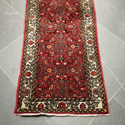 232 - Red ground runner with 3 multicolour Geometric central medallions within  fauns border, 70cm x 200cm... 