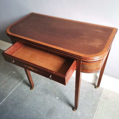 103 - Reproduction mahogany fold over card table with inlaid & marquetry drawer terminating on 4 brass cas... 