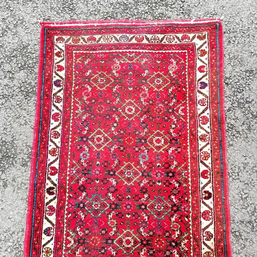 366 - Persian red grounded hand woven wool rug / runner - 412cm x 80cm ~ has mark to 1 part otherwise in g... 