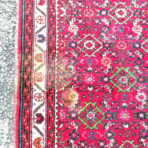 366 - Persian red grounded hand woven wool rug / runner - 412cm x 80cm ~ has mark to 1 part otherwise in g... 