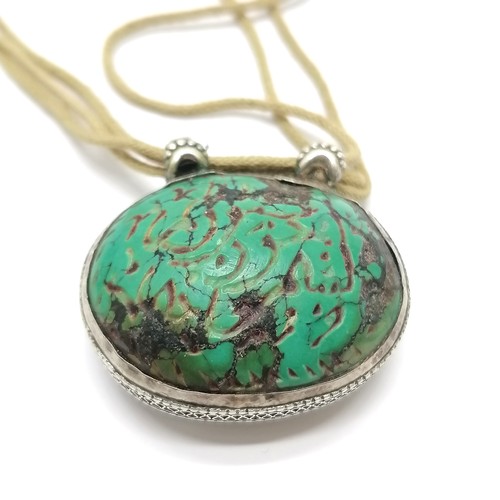 657 - Antique Islamic carved turquoise amulet set in unmarked silver with text to one side and a deer to t... 