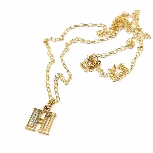 697 - 9ct marked gold H pendant set with a diamond on a 9ct marked gold 46cm chain - 1.2g total weight