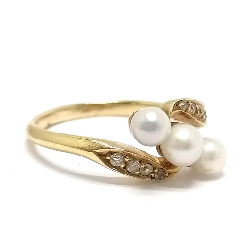 710 - Unmarked gold (touch tests as 18ct) diamond & pearl crossover ring - size M & 3.3g total weight