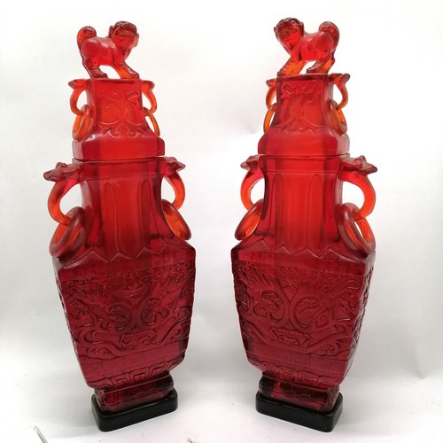 26 - Oriental pair of red amber coloured lidded decorative vases with dogs of fo detail to tops t/w match... 