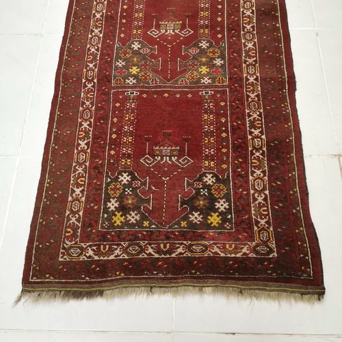 143 - Red ground rug with all over decoration within multiple borders, in good used condition, 102 cm wide... 