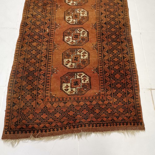 144 - Brown ground rug with 5 central medallions within large border, in good used condition 110 cm wide x... 