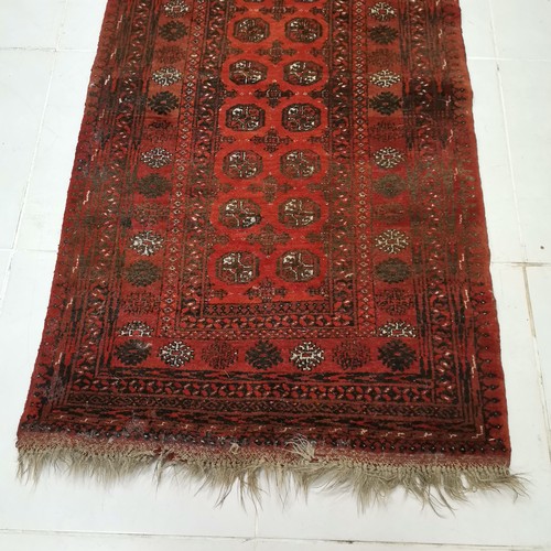 145 - Red ground rug with numerous medallions within large border, in good condition 104 cm wide x 184 cm ... 