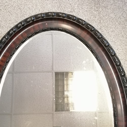 195 - Antique large oval wall bevel edged mirror with faux wood scumble detail - 88cm x 63cm and has sligh... 