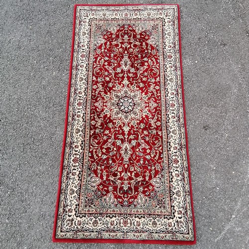 71 - Small red grounded wool rug with cream detail to the border 158cm x 78cm - in good used condition