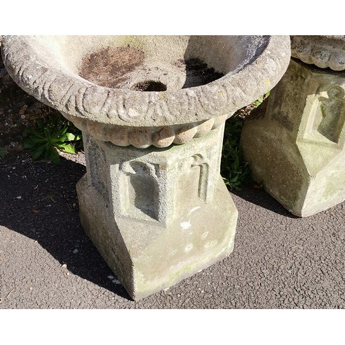 24 - Pair of garden concrete urns with fluted tops, resting on ecclesiastical inspired bases, 60 cm diame... 