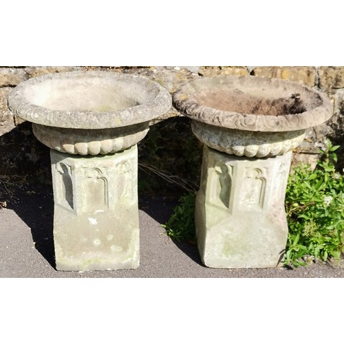 24 - Pair of garden concrete urns with fluted tops, resting on ecclesiastical inspired bases, 60 cm diame... 