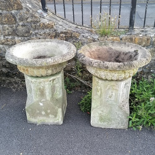 24 - Pair of garden concrete urns with fluted tops, resting on ecclesiastical inspired bases, 60 cm diame... 