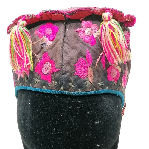 132 - Antique Chinese embroidered cloth hat pink decorated with flowers and has tassels - has signs of wea... 