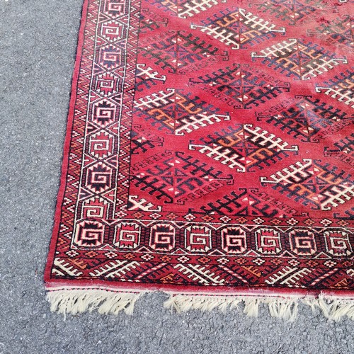 189 - Hand woven Eastern red grounded carpet with repeat geometric patterns - 215cm x 300cm - signs of mot... 