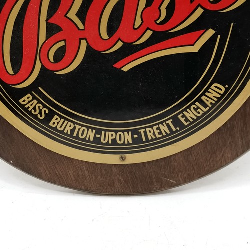 202 - Bass ale enamelled advertising sign mounted on a wooden shield - 57cm x 47cm