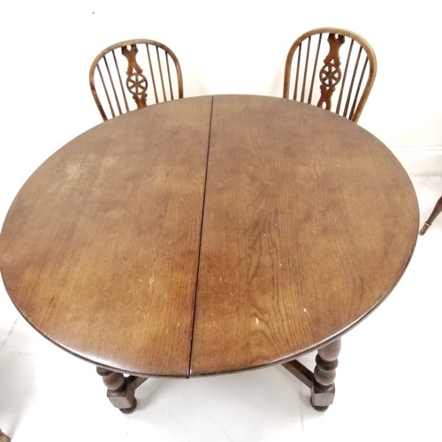 274 - Circular dark oak extending table  with 6 matching  Windsor chairs including 2 carvers all with crin... 