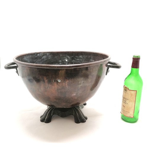 351 - Anjtique copper coal bin / planter with 2 handles on cast metal base - 43cm diameter and has 2 drill... 