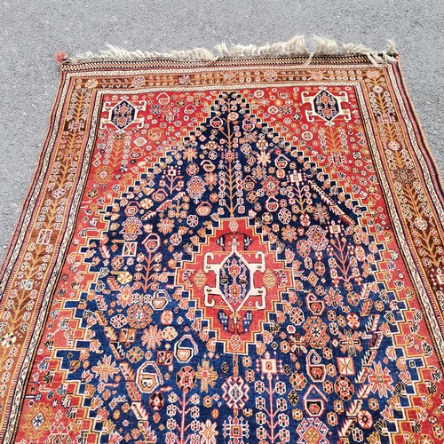 167 - Persian red grounded wool rug - 227cm x 150cm - in good used condition