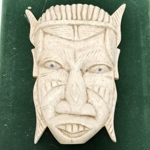 171 - Bone carved tribal mask on a velvet plaque - 27cm x 20cm - no obvious signs of damage