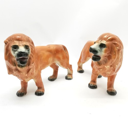 84 - Pair of antique Staffordshire standing lion figures 26cm high x 32cm long - 1 leg has an old repair ... 