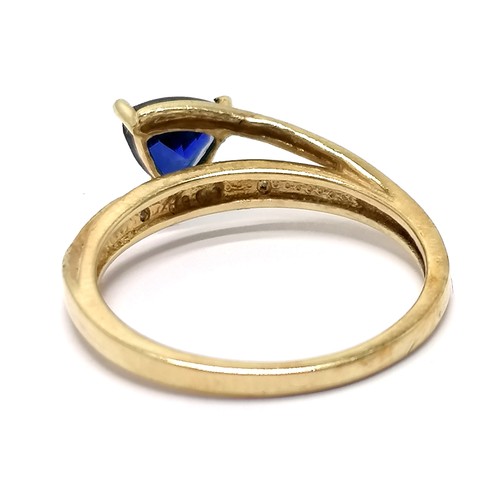 591 - 10ct marked gold ring high set with triangular cut sapphire with diamond set shoulders - size N½ & 2... 