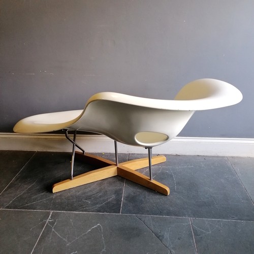 204 - Eames style white chaise longue made up of a lacquered polyester resin seat on a beech and chrome ba... 