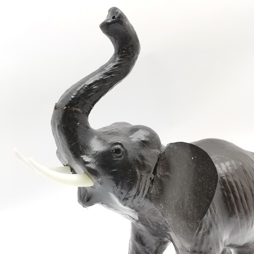 244 - Leather model of an elephant with raised trunk - 46cm high ~ slight crack to trunk