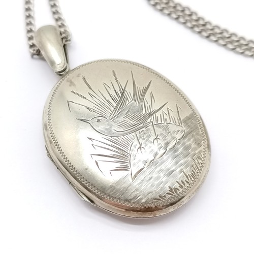 605 - Antique unmarked silver locket with bird detail (5.5cm drop) on a silver marked 60cm chain ~ 21g tot... 