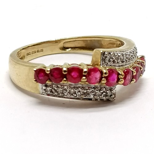 461 - 9ct hallmarked gold ruby / diamond crossover ring - size O½ & 2.6g total weight