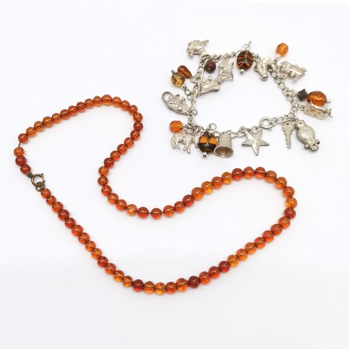 590 - Silver charm bracelet with charms (35g) t/w strand of amber beads (40cm & 8.4g total weight)