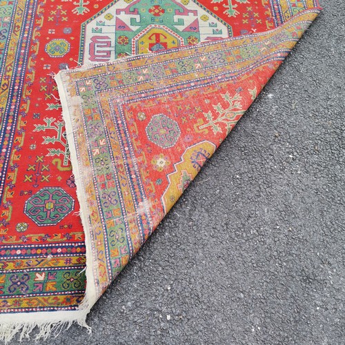 309 - Persian wool rug red grounded hand woven with geometric design - 235cm x 170cm - has some losses