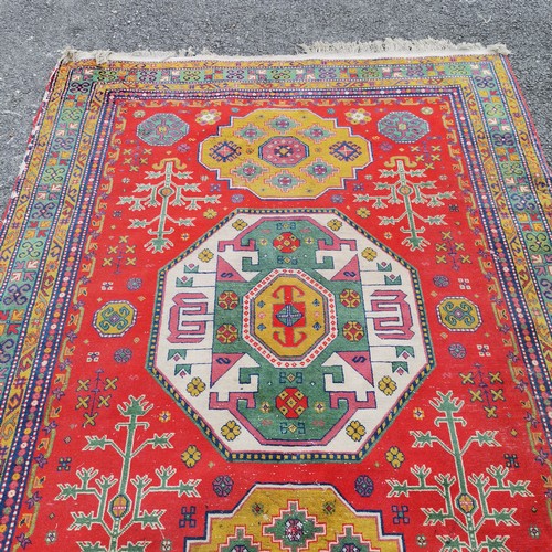 309 - Persian wool rug red grounded hand woven with geometric design - 235cm x 170cm - has some losses